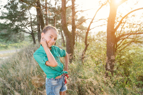 Malá roztomilá holka tráví svůj volný čas venku v lese. - Fotografie, Obrázek
