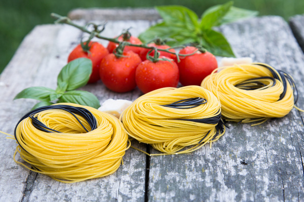 Italian food background with tomatoes, basil, spaghetti, parmesa - Photo, Image
