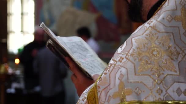 Pappi lukee rukouksen avoimesta Raamatusta.
. - Materiaali, video
