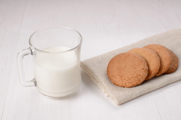 Homemade ginger cookies with a glass of milk on a wooden light b - Fotó, kép