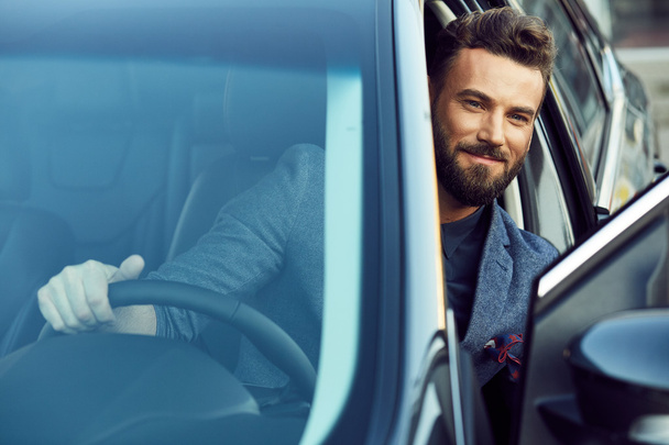 Handsome smiling man driving a car - Foto, afbeelding