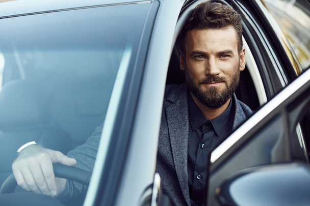 Attractive young businessman in a car - Foto, Imagen