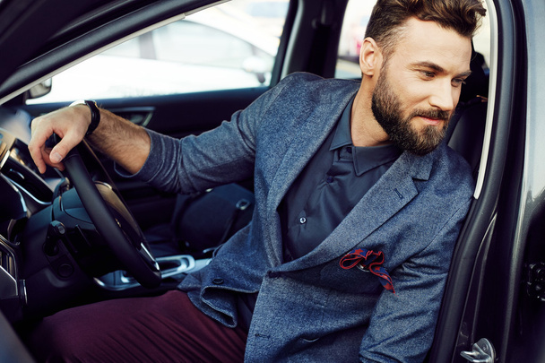 Portrait handsome elegant man in a car on driver's place - Fotografie, Obrázek