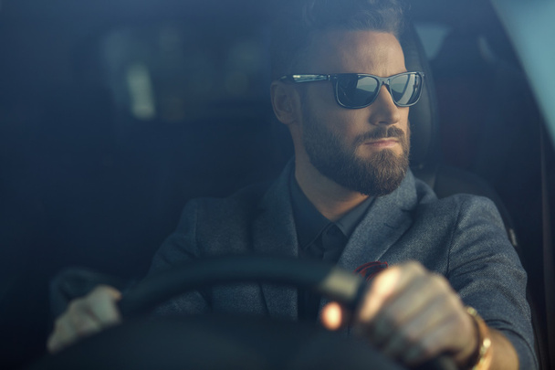 Handsome serious man in a car - 写真・画像