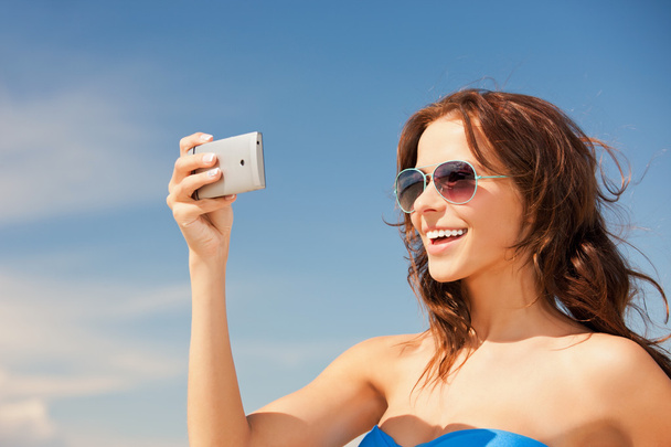 Happy woman with phone on the beach - 写真・画像