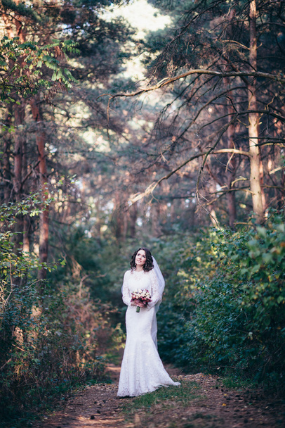 Beautiful bride outdoors in a forest. - Fotó, kép