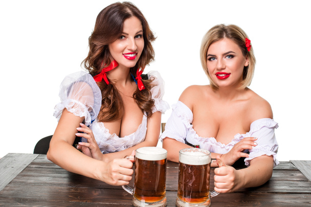 Dos hermosas chicas rubias y morenas de oktoberfest cerveza stein
 - Foto, Imagen