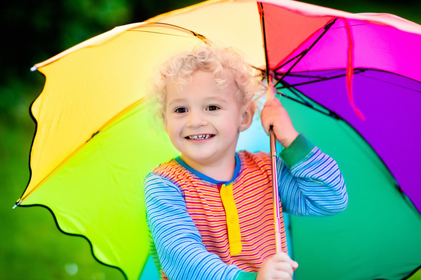 Μικρό αγόρι που παίζει στο βροχερό καλοκαιρινό πάρκο - Φωτογραφία, εικόνα