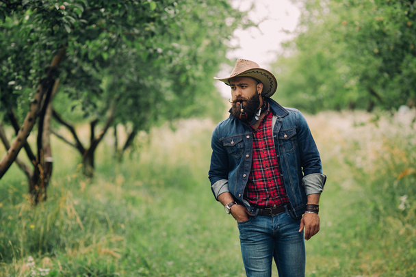 Bearded cowboy in garden - Фото, зображення