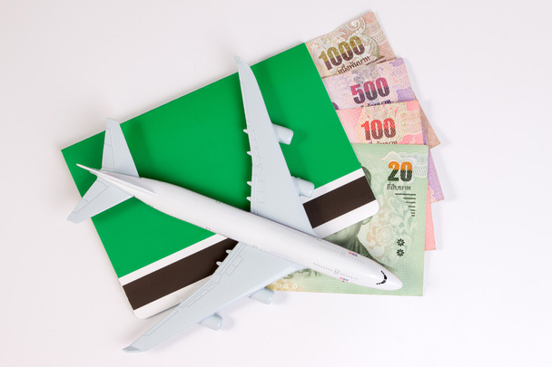 Avião com dinheiro tailandês, os custos crescentes das viagens aéreas. Bilhetes de avião ou banco de livro isolado em branco, vista superior
. - Foto, Imagem