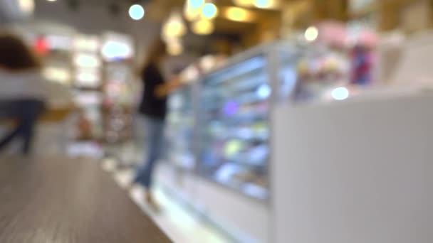 Young woman choosing chocolates in pastry shop. 4K background bokeh video - Footage, Video