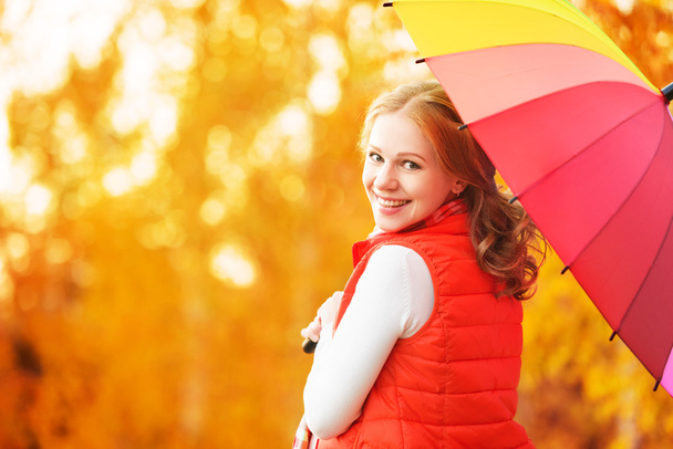 Gelukkige vrouw met regenboog veelkleurige paraplu onder regen in par - Foto, afbeelding