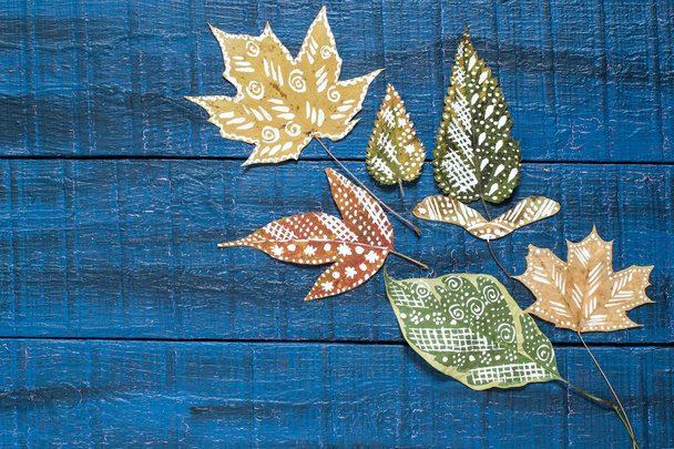 Pintado a mano sobre hojas secas de otoño
  - Foto, Imagen