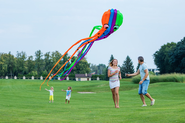 Щаслива сім'я літає повітряний змій разом
   - Фото, зображення