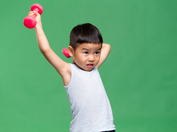 little boy raising up dumbbells - Фото, изображение