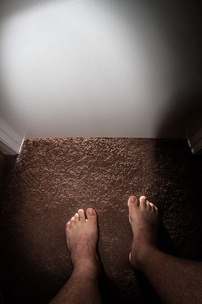 Hombre de pie frente a una puerta oscura decidiendo si debe dar un paso adelante
 - Foto, Imagen