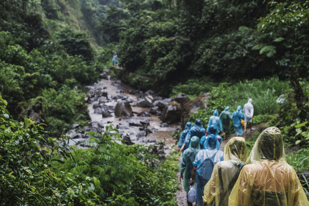 Mensen in de regenjas in heuvel wandelen in regenachtige dag, selectieve aandacht - Foto, afbeelding