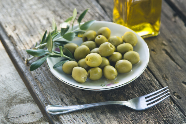 dish of olives on wooden background - Foto, Imagen