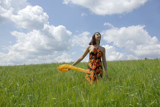 Beautiful woman in green grass field and cloud sky - Foto, Imagen