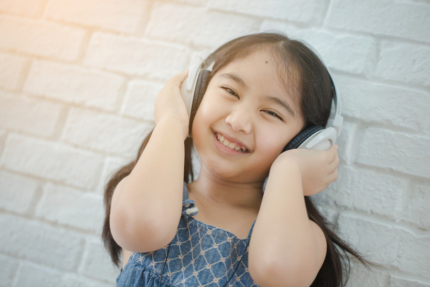 Szczęśliwa dziewczyna azjatyckich słuchania muzyki przez słuchawki - Zdjęcie, obraz
