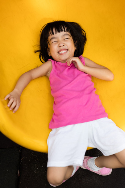 Asian Chinese little girl sliding at playground - Foto, afbeelding
