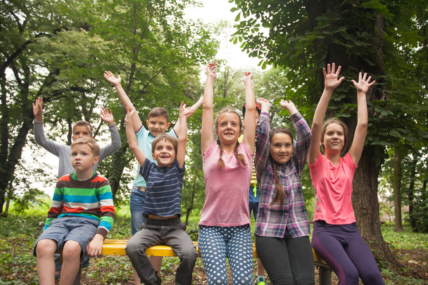 Grupo de niños en un banco del parque
 - Foto, imagen