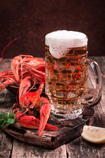 boiled crawfish and beer on a wooden background - 写真・画像