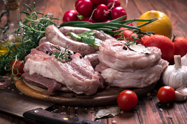 Fresh butcher cut meat assortment garnished with fresh rosemary on wooden table - Φωτογραφία, εικόνα