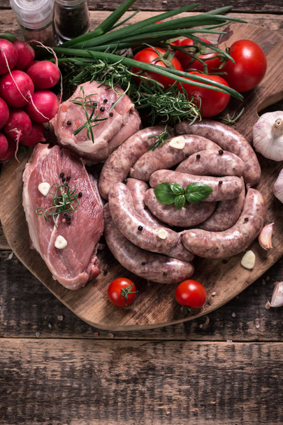 Fresh butcher cut meat assortment garnished with fresh rosemary on wooden table - Φωτογραφία, εικόνα