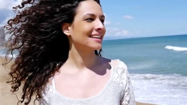 Muotokuva onnellinen nuori nainen kaunis kihara tukka meren rannalla, hidastettuna
 - Materiaali, video