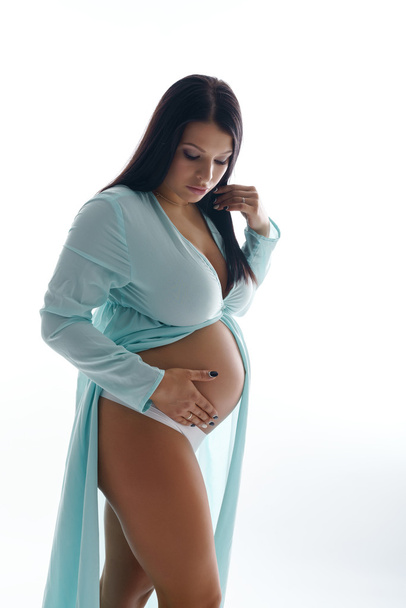 Atractiva madre embarazada tocando su vientre
 - Foto, imagen