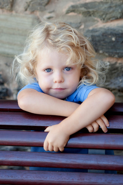 Petit enfant caché derrière un banc en bois
 - Photo, image