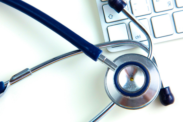 stetoscopio medico vicino al laptop su tavolo di legno, bianco
 - Foto, immagini