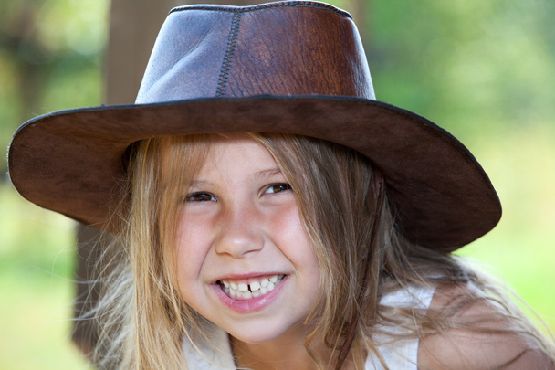 Toothy smile of young pretty girl in cowboy hat, facial portrait - Zdjęcie, obraz