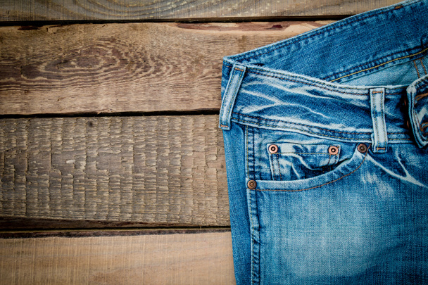 джинси на дерев'яному столі
 - Фото, зображення