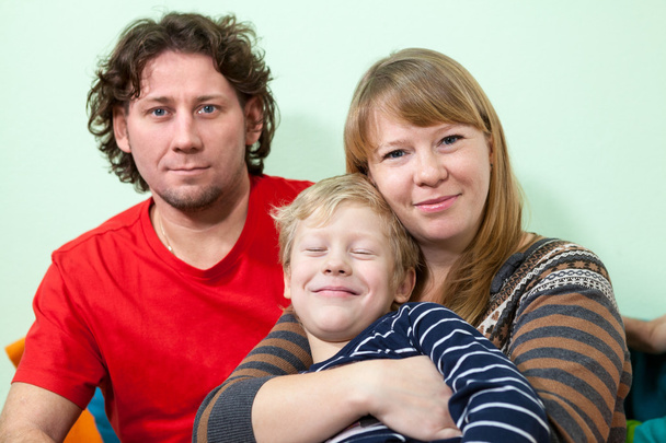 Happy Caucasians embracing family portrait with smiling son - Фото, зображення