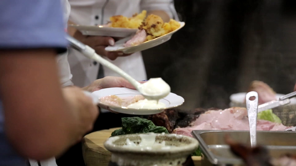 Cook and waiters serves roasted meat at the party - Materiał filmowy, wideo