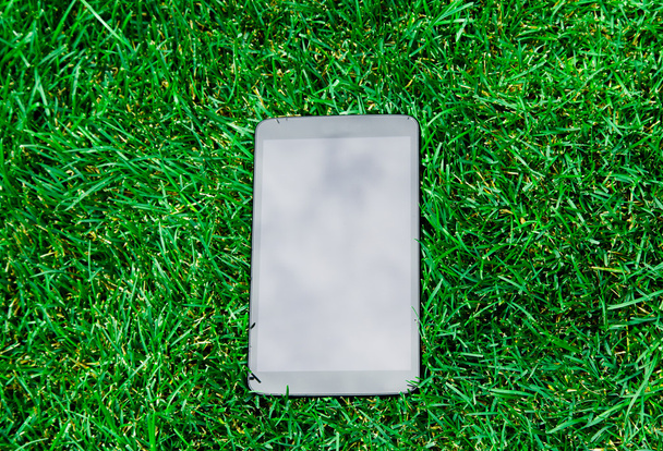 tablet on green grass - Foto, imagen