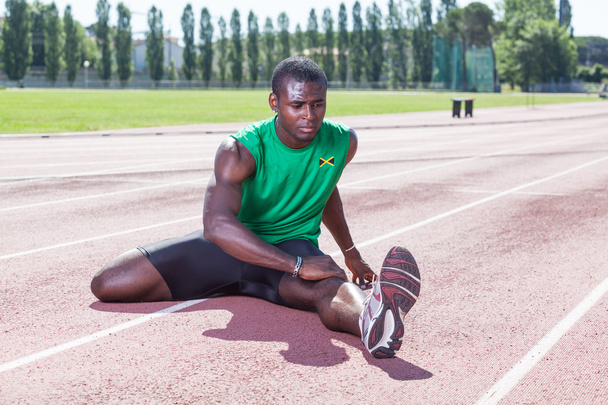 Track and Field Athlete Stretching - Foto, Imagem