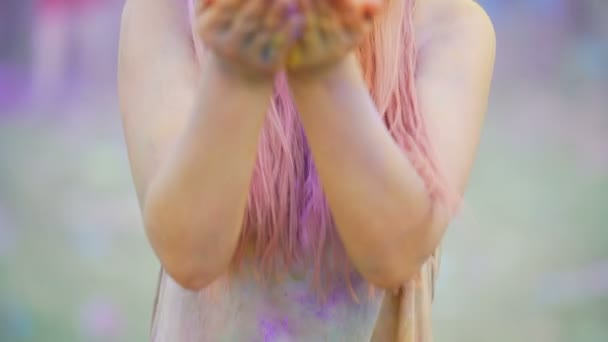 Happy face of girl enjoying Holi festival atmosphere, blowing colors to camera - Metraje, vídeo