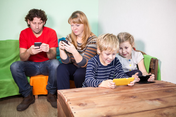 All family having fun with the games on smartphones - Фото, изображение