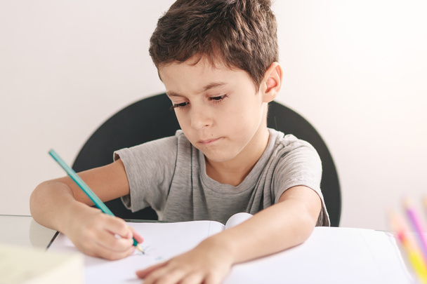 Szczery portret chłopca jego odrabiania lekcji i nauki w domu - Zdjęcie, obraz