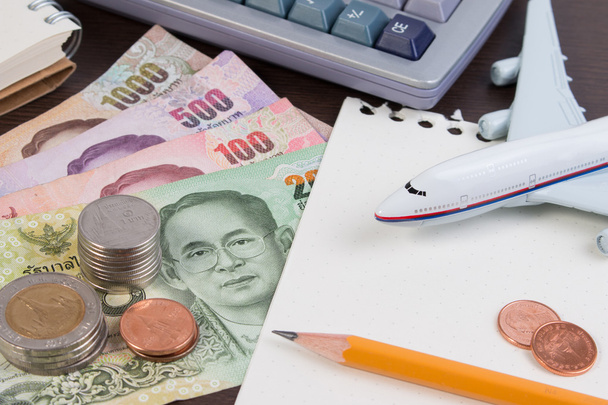 Pasaporte tailandés con billete de dinero tailandés, moneda tailandesa y avión
.  - Foto, imagen