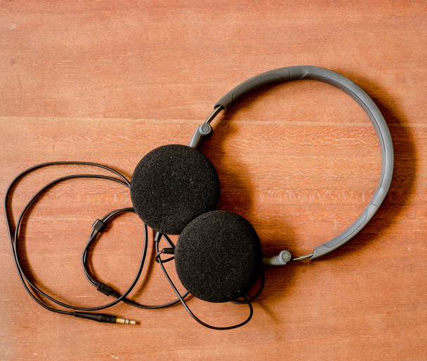 Μαύρα ακουστικά στο παλιό ξύλο Διοικητικό Συμβούλιο - Φωτογραφία, εικόνα