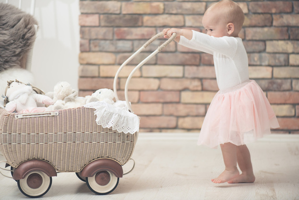 Bébé fille avec jouet bébé chariot
 - Photo, image