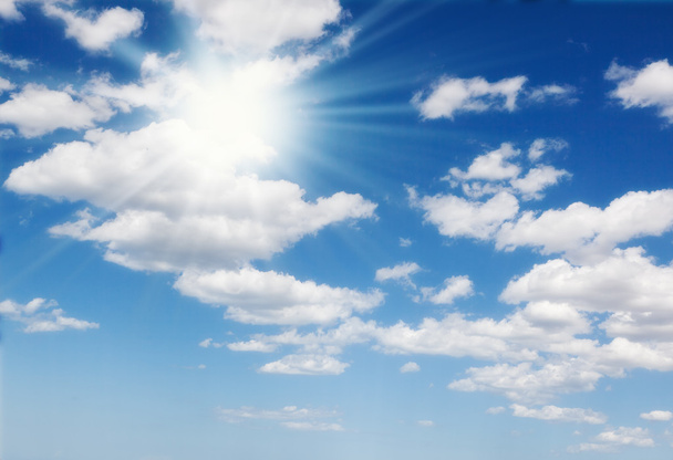 Blauwe lucht met wolken en zon - Foto, afbeelding