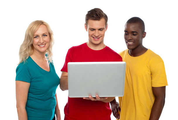 Cheerful group of friends working on laptop - Фото, зображення
