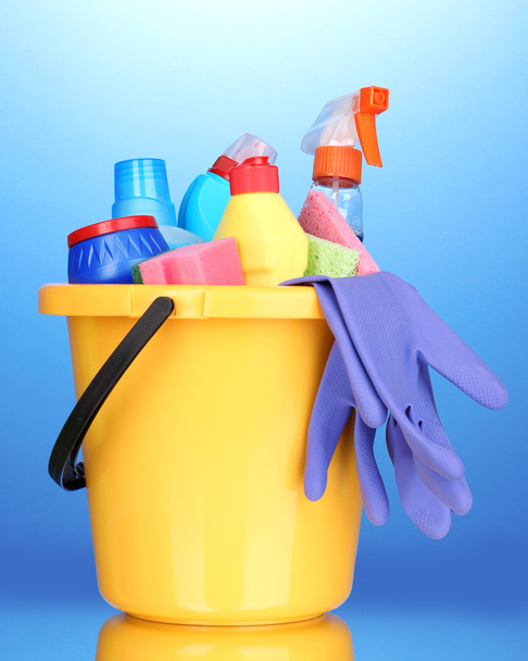 Bucket with cleaning items on blue background - Foto, Imagem