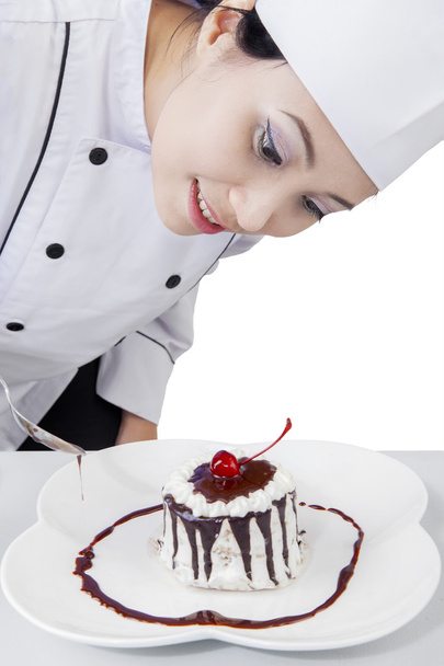 Chef gives decoration on a cake - Foto, afbeelding
