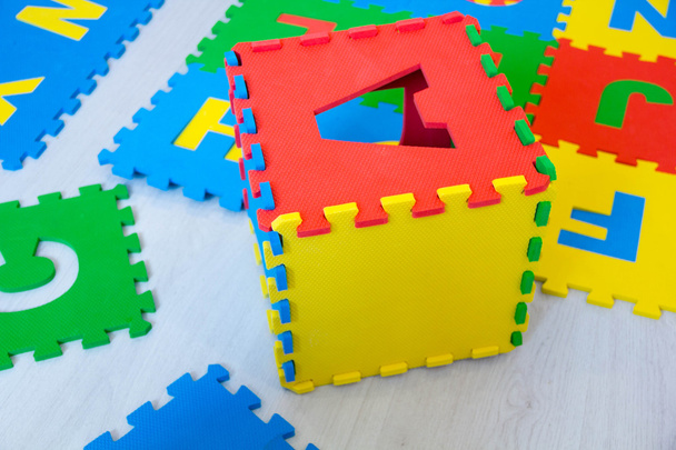 tapetes educativos coloridos para quebra-cabeças de crianças, que estão na moda para coletar nas caixas com o alfabeto inglês, ensinar as letras às crianças, desenvolvimento precoce, brincando com crianças, brinquedos úteis
 - Foto, Imagem